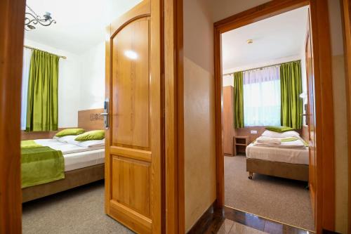 a room with two beds and a door to a bedroom at Pod Tatrami 1 - świetna lokalizacja - sauna fińska oraz infrared i grota solna - jedno wejście gratis in Białka Tatrzanska
