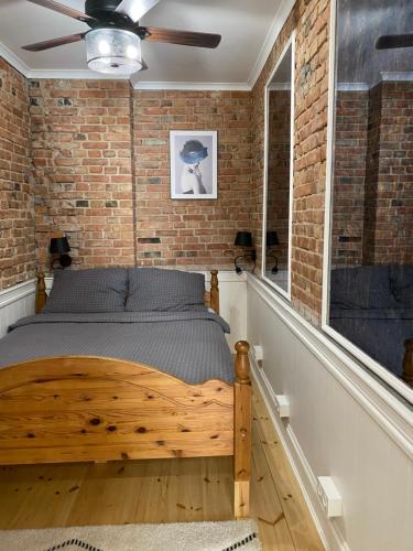 a bedroom with a brick wall and a wooden bed at Apartments PSD - Anny Łajming 1A in Słupsk