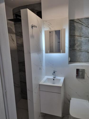 a white bathroom with a sink and a mirror at Strict center Warsaw comfortable apartment, 10th-floor with beautiful view on the park and skyscrapers, free WiFi, self check-in/out in Warsaw