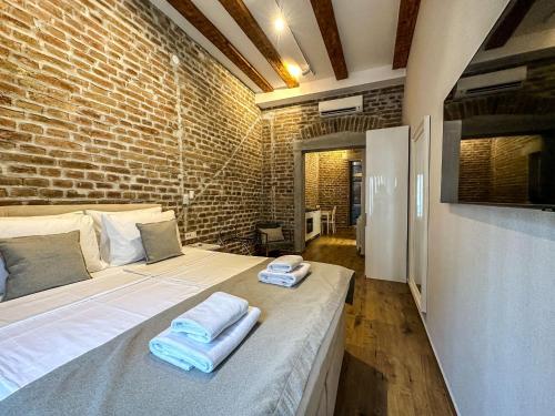 a large bed in a room with a brick wall at Old Town Apartments Rajiceva 3 in Belgrade