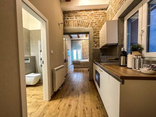 a kitchen with wooden floors and a brick wall at Old Town Apartments Rajiceva 3 in Belgrade