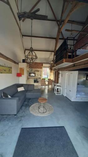 a living room with a couch and a table at appartement in authentiek koetshuis met bedstee in Moerstraten
