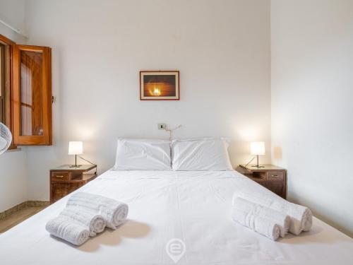 a bedroom with a white bed with two towels on it at Marine View House in Putzu Idu