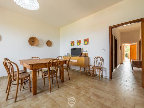 a dining room and living room with a table and chairs at Marine View House in Putzu Idu