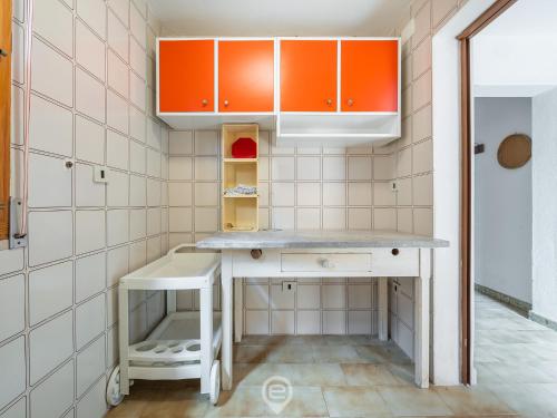 a kitchen with orange and white cabinets and a table at Marine View House in Putzu Idu