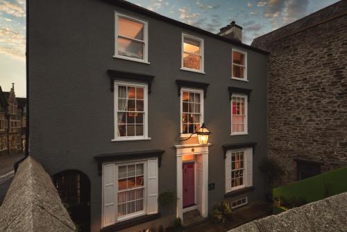 uma casa preta com janelas brancas e uma porta vermelha em One Drake Road, Tavistock, Devon em Tavistock