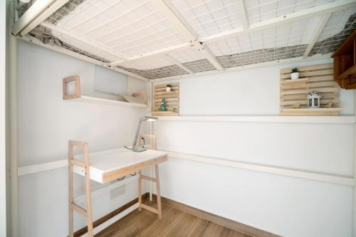 Habitación con pared blanca y escritorio. en Estudio Limón y Sal, en Chiclana de la Frontera