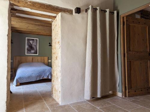 a bedroom with a bed and a door with a curtain at Val Trebbia in Feucherolles