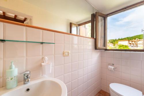 a bathroom with a sink and a toilet and a window at La Finestra Sul Fiume in Subbiano