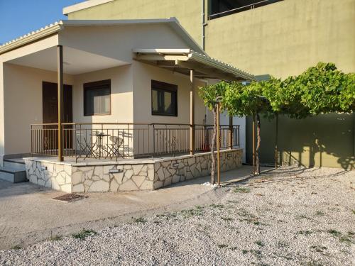 a house with a balcony with a fence at Backyard Apartment in Lefkada Town