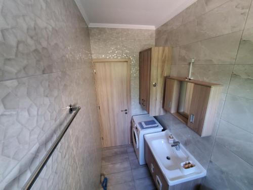 a bathroom with a sink and a washing machine at Backyard Apartment in Lefkada