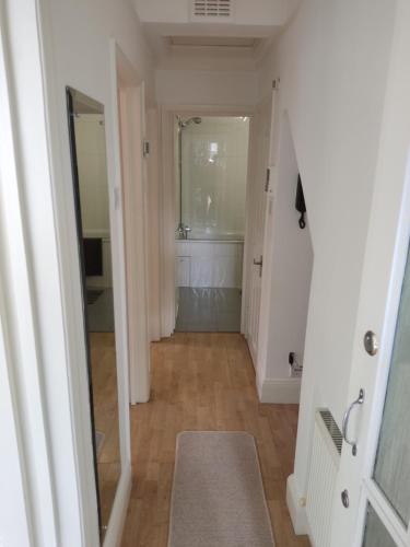 a hallway of a bathroom with a sink and a mirror at Cosy Apartment in North London - Great Location in London