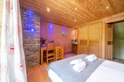 a bedroom with a bed and a stone wall at Le Bûcher d'Albert in Champagny-en-Vanoise