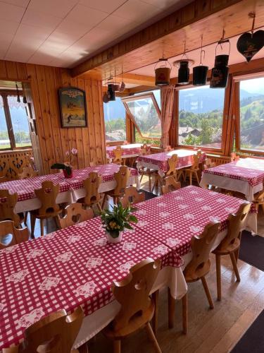 a restaurant with tables and chairs with pink table cloth at Hotel Les Granits in Combloux