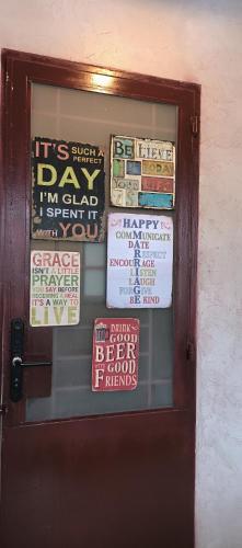 a door with a bunch of signs on it at T Zone Hostel - Quiet Place, Near China Town,Ho Thi Ky Street Food,Cafe,Beer in Ho Chi Minh City