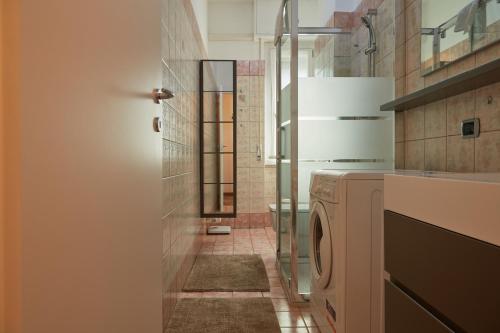 uma casa de banho com um chuveiro e uma máquina de lavar roupa em Hotel Lido em Milão