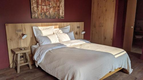 a bedroom with a large bed with a wooden headboard at Val Trebbia in Feucherolles