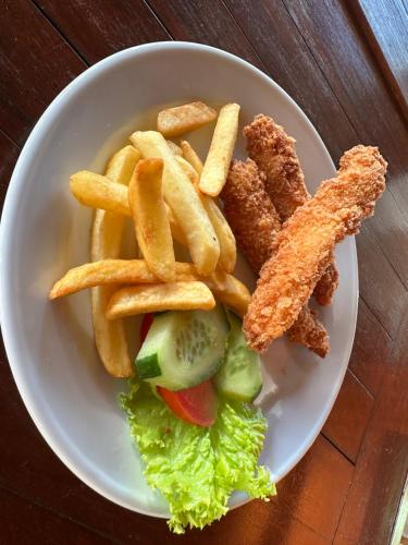 a plate of food with fried fish and french fries at VILLA IPSA in Munduk