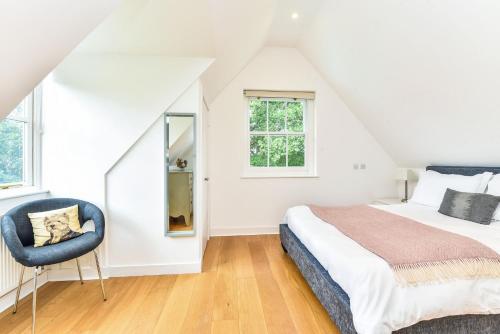 a bedroom with a bed and a chair at The Poolhouse by Inspire Stays in Petworth