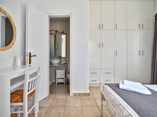a white bedroom with a sink and a mirror at Antiparos View in Antiparos