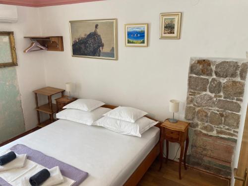 a bedroom with a bed and a stone wall at Guesthouse Vicelic in Dubrovnik