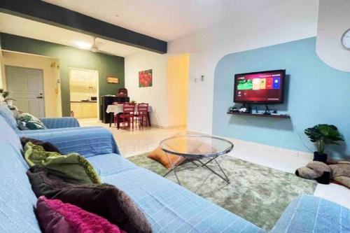 a living room with a blue couch and a tv at 3BR 8PAX KL City Centre KLCC View Ampang Boulevard Condo in Ampang