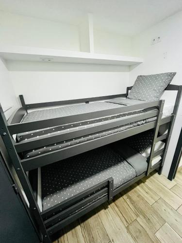 Cette chambre comprend un lit superposé noir avec une chaise. dans l'établissement Studio piscine plages à pied, à La Grande Motte