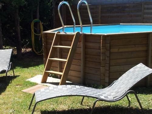 two chairs and a ladder next to a swimming pool at Gite Entre Cévennes et Méditerranée in Cazilhac