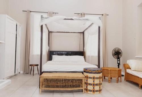 a bedroom with a canopy bed and a couch at Paphiri House in Zomba