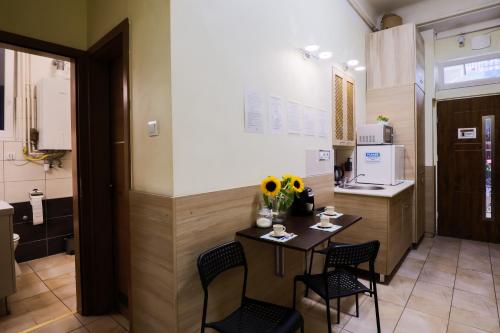 cocina con mesa, 2 sillas y barra en East Station Private Rooms & Apartments, en Budapest