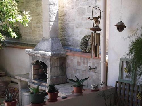 a patio with an outdoor oven with potted plants at Gite Entre Cévennes et Méditerranée in Cazilhac