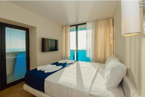 Orbi City Apartments Batumi في باتومي: غرفة نوم بسرير كبير ونافذة كبيرة