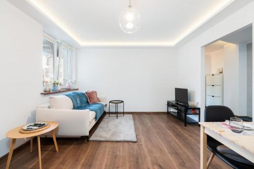 a living room with a white couch and a table at Kosińskiego Apartament Poznań by Noclegi Renters in Poznań