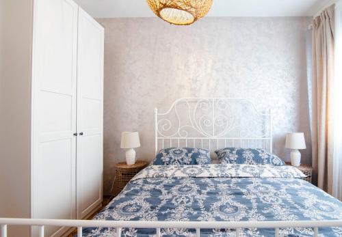 een slaapkamer met een blauw en wit bed en een kroonluchter bij Apartman Karla in Sinj