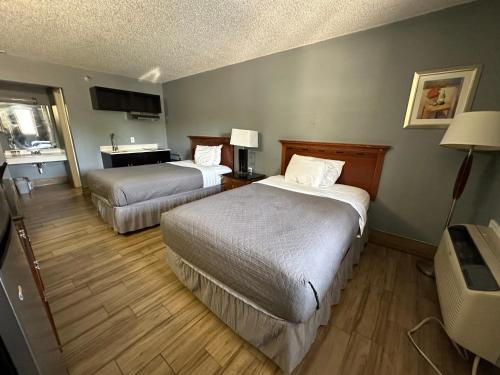 a hotel room with two beds and a desk at HillView Inn at Six Flags Fiesta in San Antonio