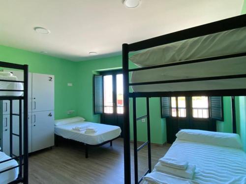 two bunk beds in a room with green walls at O TEU SITIO in Ribadeo