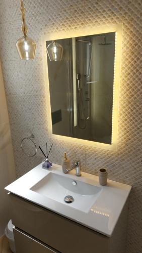a bathroom with a white sink and a mirror at Semiramis Apartment in Potamós