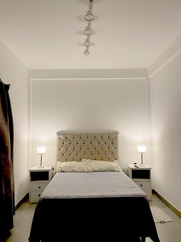 een slaapkamer met een groot bed met 2 nachtkastjes bij Latorre Apartment in Salta