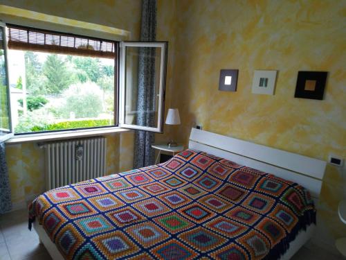 a bedroom with a bed and a window at La Casa di Ortensia in Parma