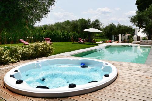 bañera de hidromasaje en una terraza junto a la piscina en IL TRULLO BIANCO - Country House & SPA, en Castellana Grotte