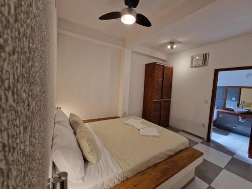 a bedroom with a bed and a ceiling fan at PIPA BAVARIA BEIRA MAR in Pipa