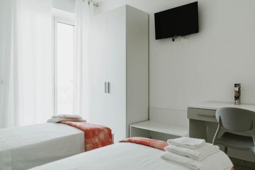 カザルボルディーノにあるCASALMAREのベッド2台、デスク、コンピュータが備わる客室です。