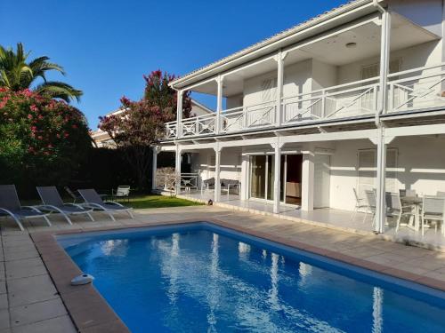 une maison avec une piscine devant dans l'établissement Villa Piscine Golf Tennis Méditerranée, à Baillargues
