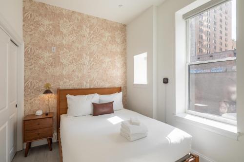 a bedroom with a white bed and a window at Sosuite at French Quarters - Rittenhouse Square in Philadelphia