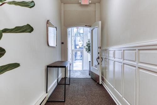 a hallway with a table and an open door at Sosuite at French Quarters - Rittenhouse Square in Philadelphia