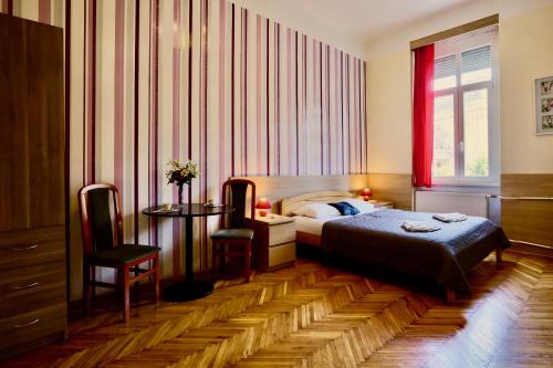 ブダペストにあるEast Station Private Rooms & Apartmentsのベッドルーム1室(ベッド1台、テーブル、窓付)