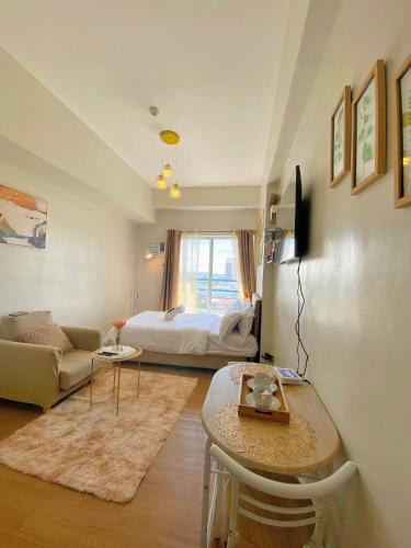 a living room with a bed and a table at 11F Condo at The Loop Tower Limketkai Center CDO in Cagayan de Oro