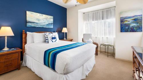 a bedroom with a bed and a blue wall at Mauna Lani Fairways 903 in Waikoloa