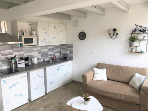 un salon avec un canapé et une cuisine dans l'établissement LA MAISON DU BONHEUR, à Rochefort