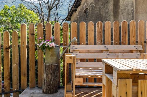 a wooden bench with a vase of flowers on it at Residence Lena App 3 with Balcony in Tenno